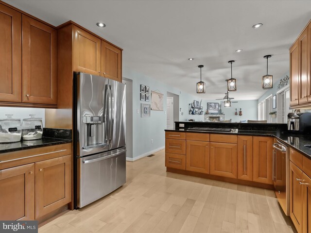 kitchen featuring appliances with stainless steel finishes, brown cabinets, a peninsula, hanging light fixtures, and recessed lighting