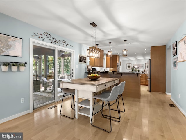 dining area featuring light wood-style flooring, baseboards, and recessed lighting