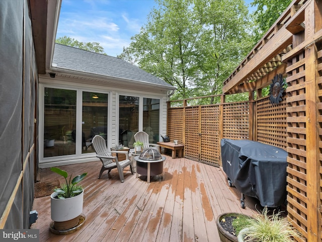 deck with a fire pit and a grill