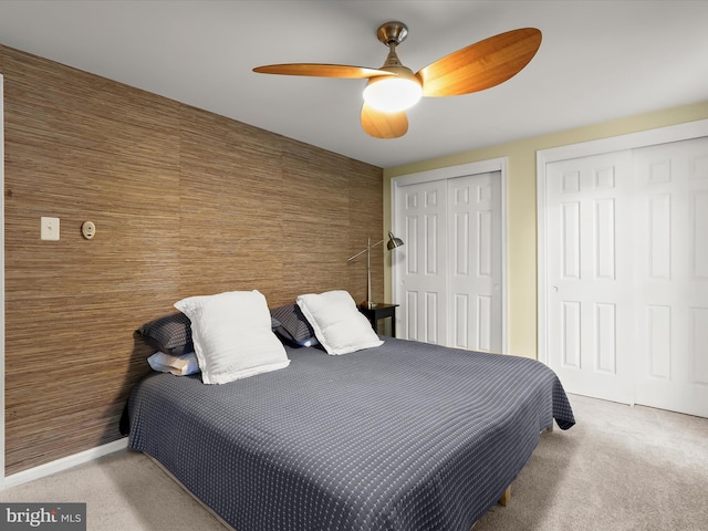 bedroom with multiple closets, carpet floors, and ceiling fan