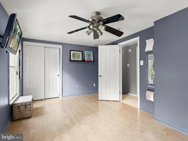 unfurnished bedroom featuring light wood-style flooring, baseboards, and a closet