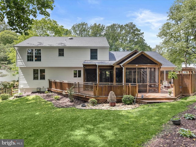 back of house with a sunroom, a deck, a yard, and a shingled roof