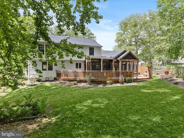 back of house featuring a sunroom, a wooden deck, and roof with shingles