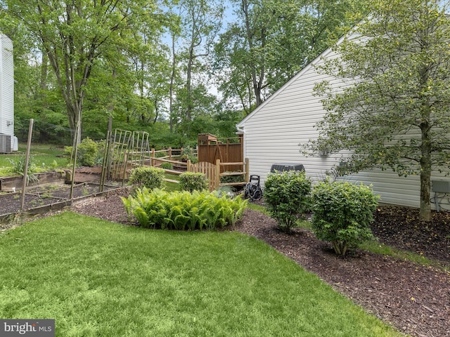 view of green lawn featuring a garden