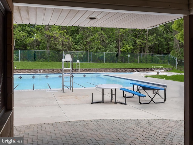 community pool with fence and a patio area