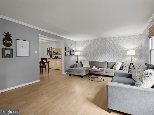 living room with crown molding, wallpapered walls, light wood finished floors, and baseboards