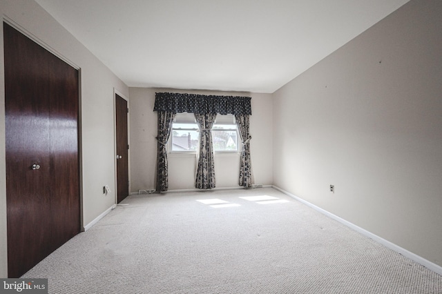 carpeted spare room featuring baseboards