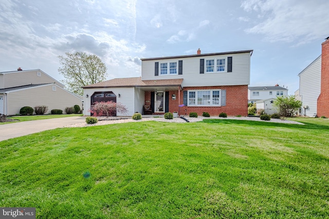 traditional-style home with brick siding, an attached garage, a front lawn, and concrete driveway