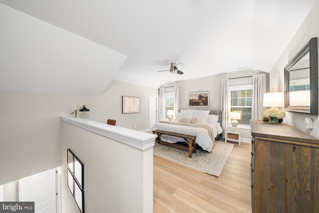 bedroom featuring a ceiling fan, light wood-type flooring, and lofted ceiling