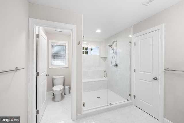 bathroom featuring toilet, a stall shower, baseboards, and visible vents