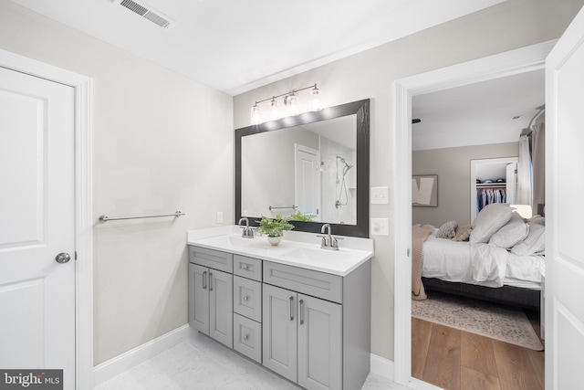 ensuite bathroom with a sink, visible vents, double vanity, and ensuite bathroom