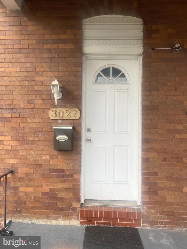 doorway to property with brick siding