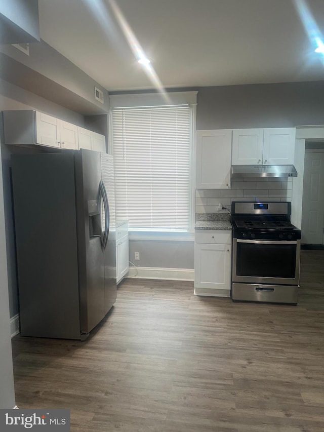 kitchen with white cabinets, appliances with stainless steel finishes, visible vents, and under cabinet range hood