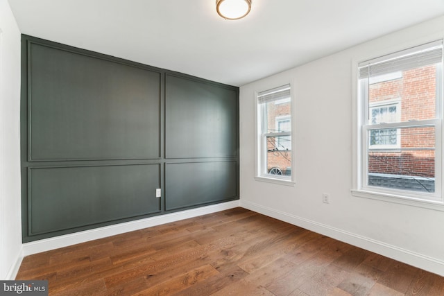 unfurnished room featuring wood finished floors and baseboards