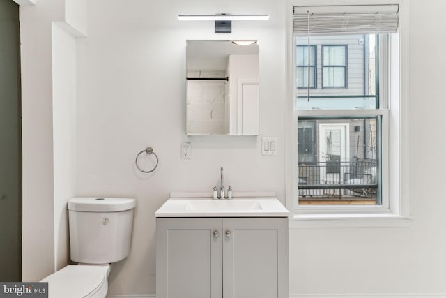 bathroom with vanity, baseboards, and toilet