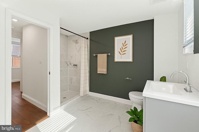 full bathroom featuring a tile shower, baseboards, a wealth of natural light, and toilet
