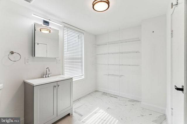 bathroom featuring vanity, marble finish floor, and baseboards