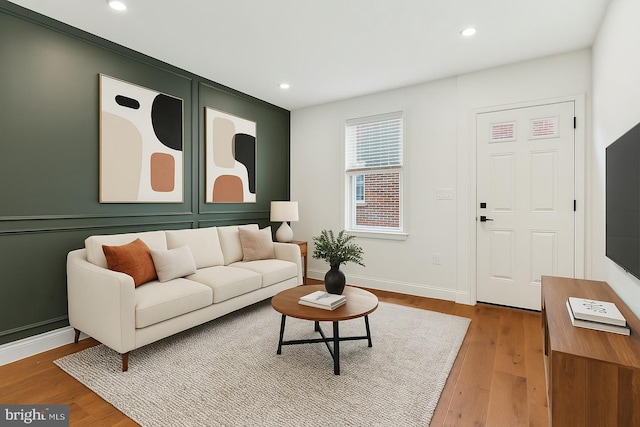 living room featuring wood finished floors, baseboards, and recessed lighting