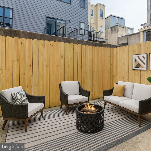 view of patio / terrace featuring fence and an outdoor living space with a fire pit