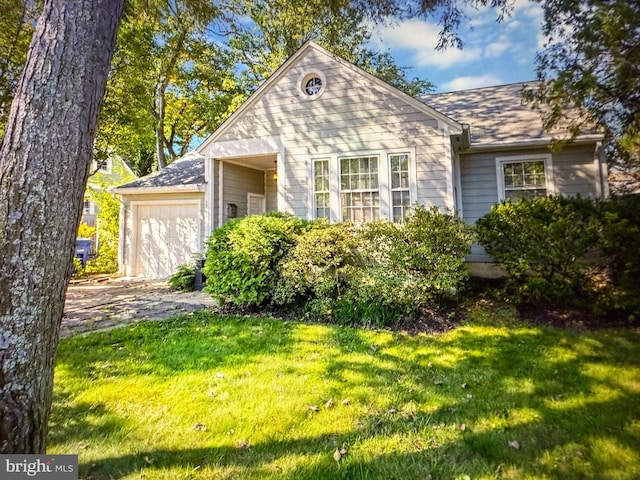view of front of home with concrete driveway, a front lawn, and a garage
