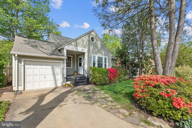 view of front of property with driveway, an attached garage, and roof with shingles