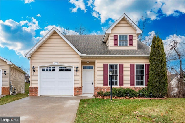 view of front facade featuring a front yard, brick siding, driveway, and an attached garage