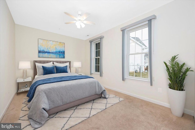 carpeted bedroom featuring baseboards and ceiling fan