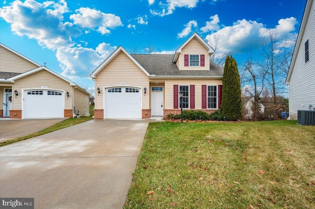 view of front of home featuring cooling unit, roof with shingles, a front yard, an attached garage, and driveway