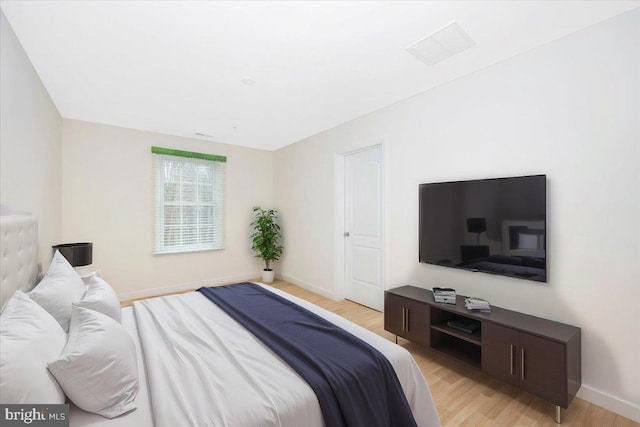 bedroom featuring light wood-style floors and baseboards