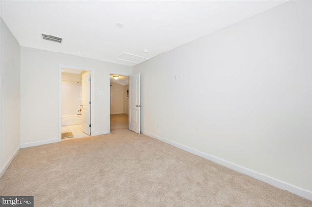 spare room featuring visible vents, baseboards, and light carpet