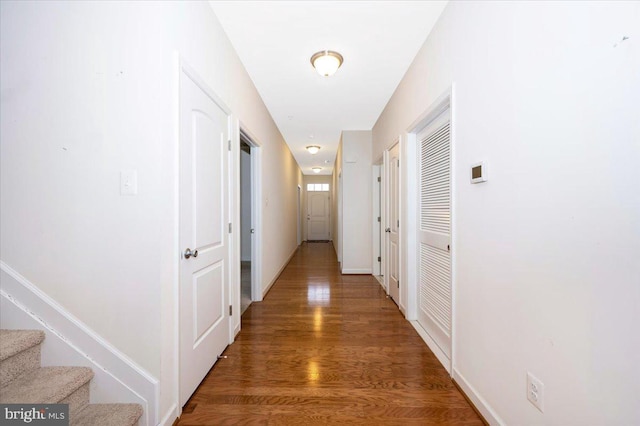 hall featuring stairway, baseboards, and wood finished floors