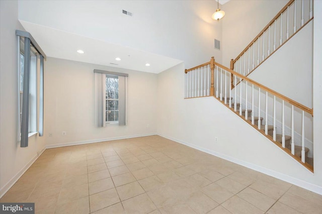 empty room with visible vents, recessed lighting, light tile patterned floors, and stairs