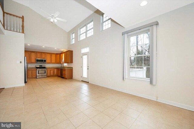 unfurnished living room featuring baseboards, a ceiling fan, plenty of natural light, and recessed lighting