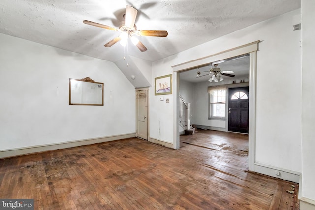 bonus room featuring hardwood / wood-style floors, ceiling fan, baseboards, and stairway
