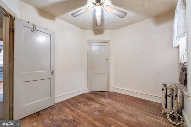 interior space with wood-type flooring, baseboards, and a ceiling fan