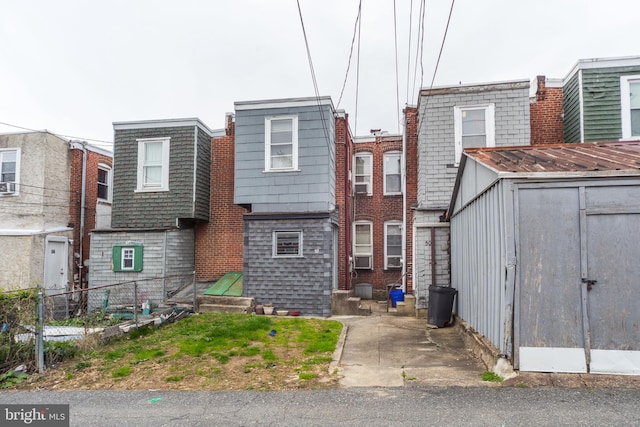 view of front of house featuring an outdoor structure, fence, and a storage unit