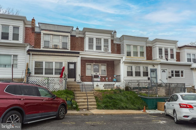townhome / multi-family property featuring brick siding and a porch