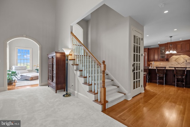 stairway featuring recessed lighting, wood finished floors, french doors, and baseboards