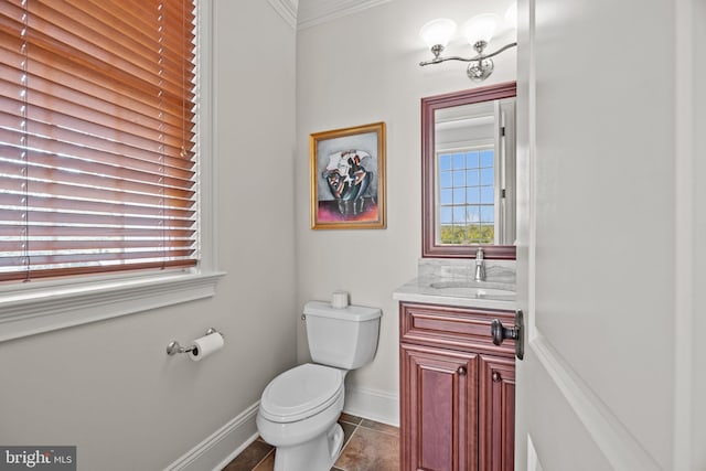 half bath featuring vanity, toilet, ornamental molding, and baseboards