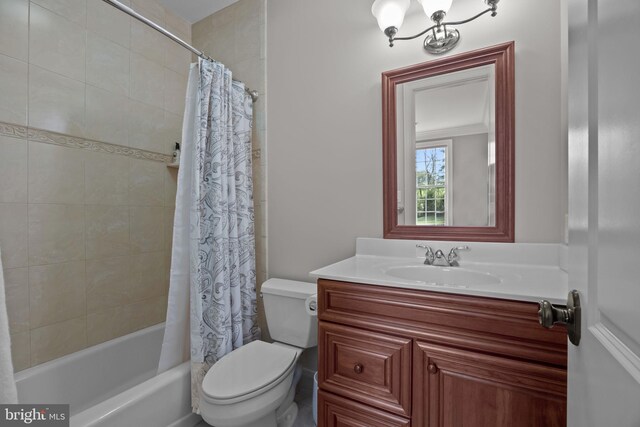 bathroom featuring shower / bath combo with shower curtain, toilet, and vanity