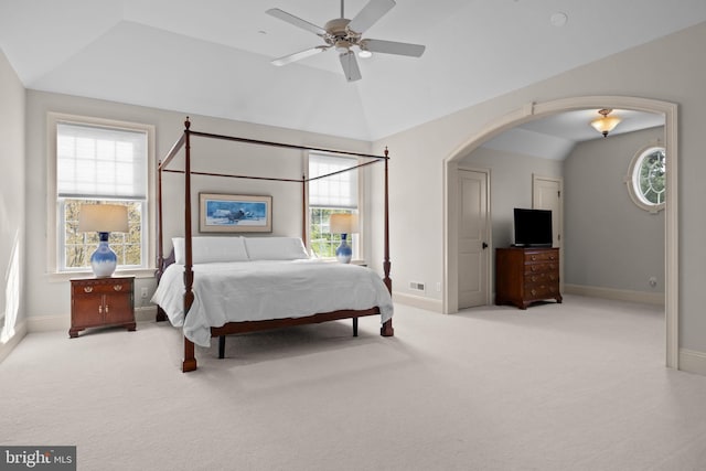bedroom featuring lofted ceiling, arched walkways, carpet floors, and baseboards