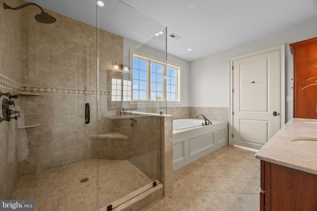 bathroom featuring visible vents, a shower stall, a bath, and vanity