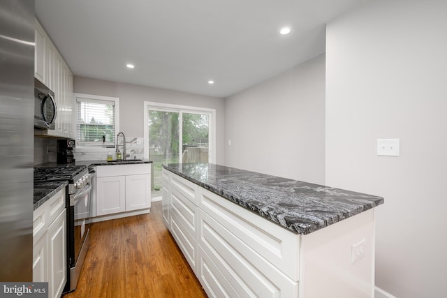 kitchen featuring recessed lighting, light wood-style floors, appliances with stainless steel finishes, and a sink