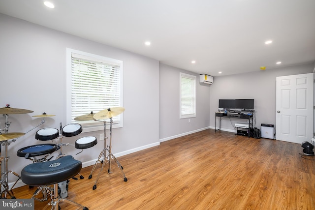 interior space featuring recessed lighting, wood finished floors, a healthy amount of sunlight, and an AC wall unit