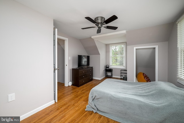 bedroom featuring vaulted ceiling, ceiling fan, baseboards, and light wood-style floors