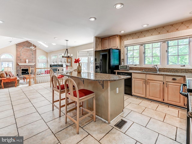 kitchen with plenty of natural light, a sink, a kitchen breakfast bar, and black appliances