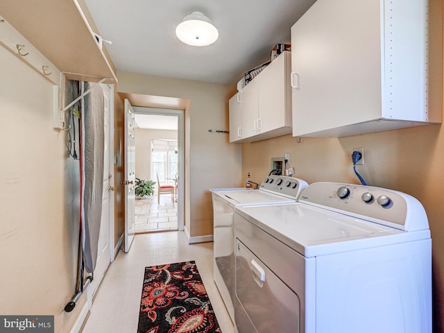 washroom with baseboards, cabinet space, and washing machine and clothes dryer