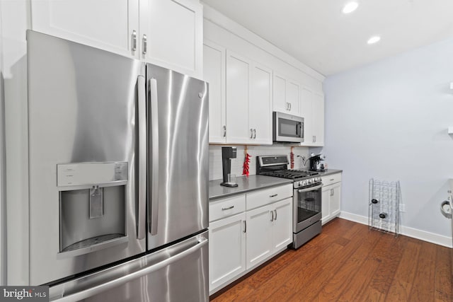 kitchen with dark wood-style flooring, decorative backsplash, white cabinets, appliances with stainless steel finishes, and recessed lighting