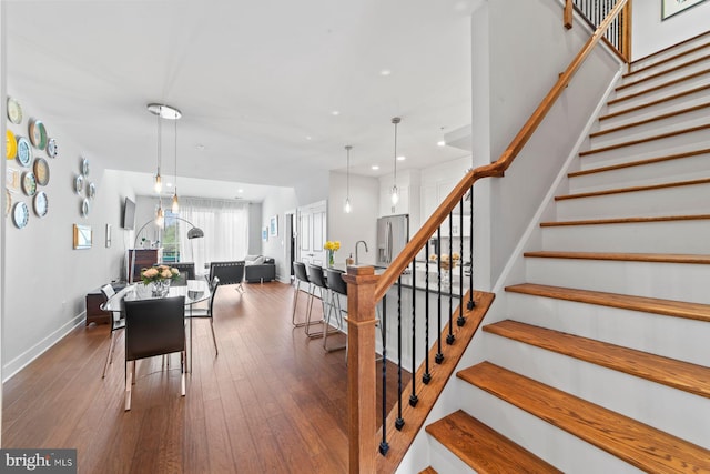 stairway with recessed lighting, hardwood / wood-style floors, and baseboards