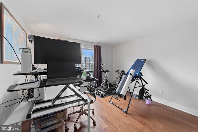 workout room featuring wood finished floors and baseboards